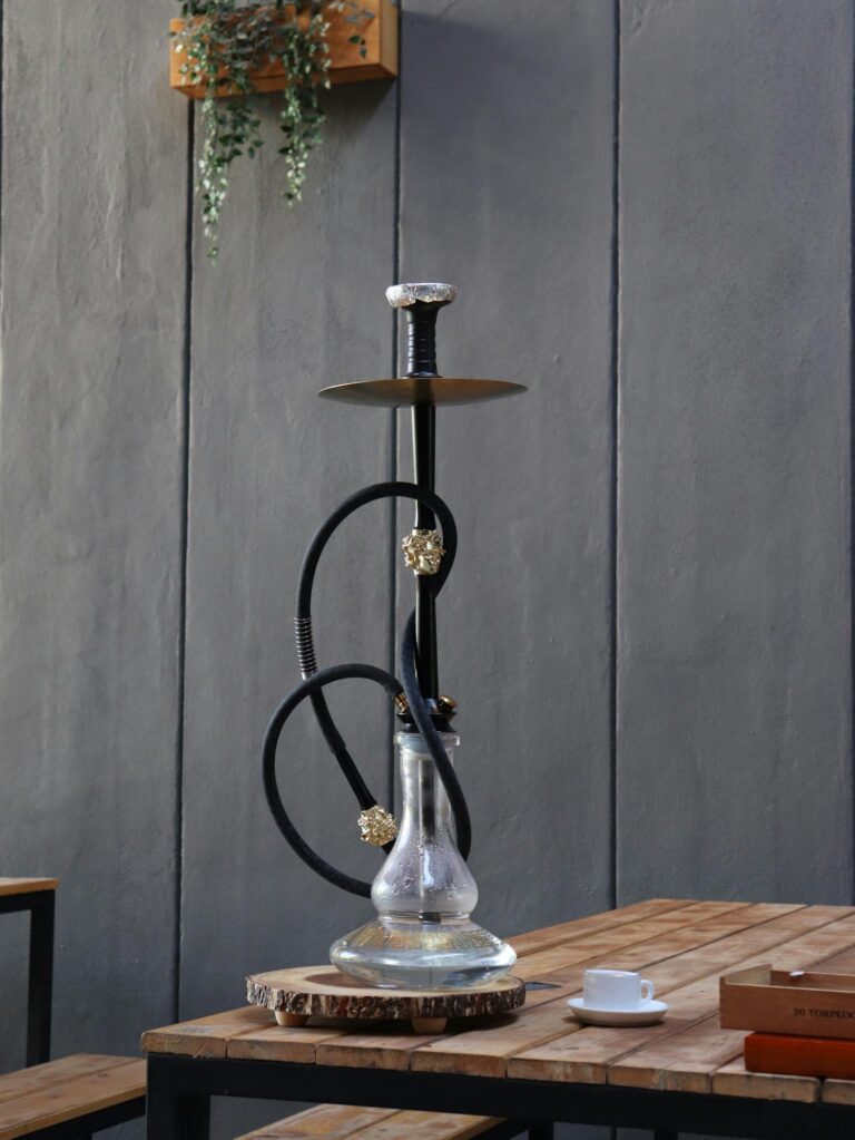 A modern cafe interior showcasing a stylish hookah setup alongside a coffee cup on a wooden table.